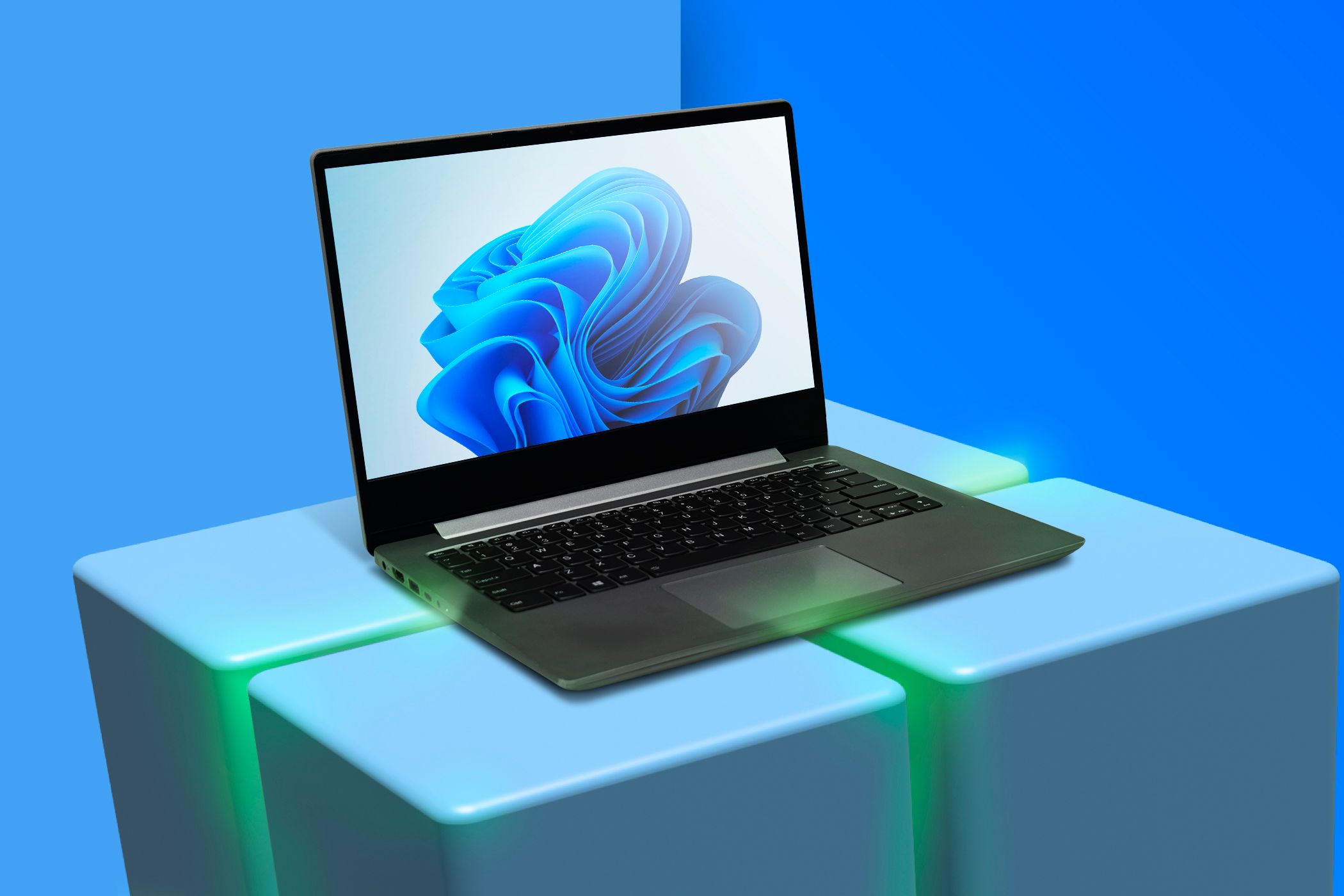 Una computadora portátil con Windows 11 sobre el logotipo 3D de Windows.