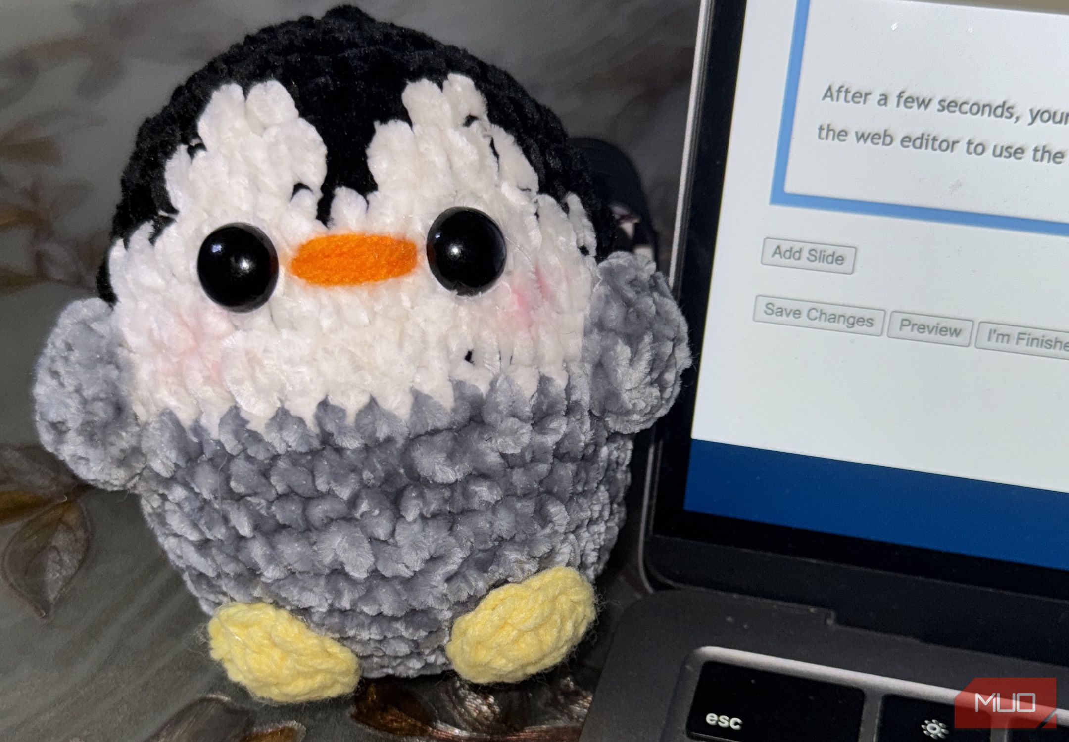 Penguin de crochet al lado de MacBook