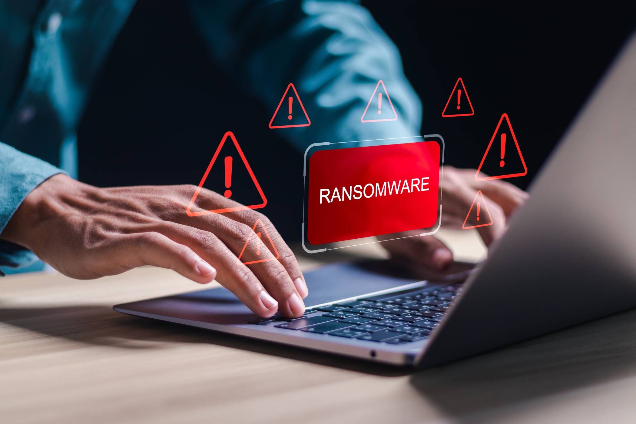 Persona en la computadora portátil con ícono de ransomware que se cierne sobre él