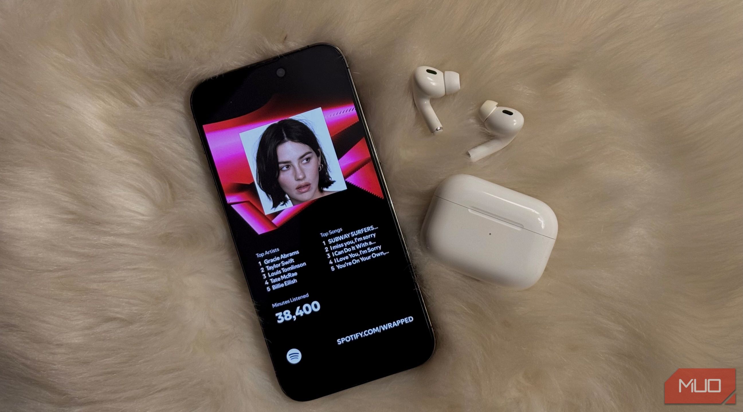 Spotify envuelto en un iPhone, con AirPods cercanos