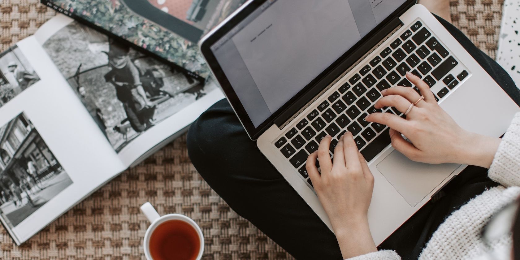 Mujer que trabaja en la computadora portátil con libros